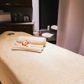 Treatment room with relaxing surroundings and towells on couch