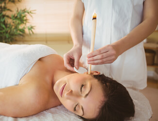 Hopi ear candle treatment relaxing on couch